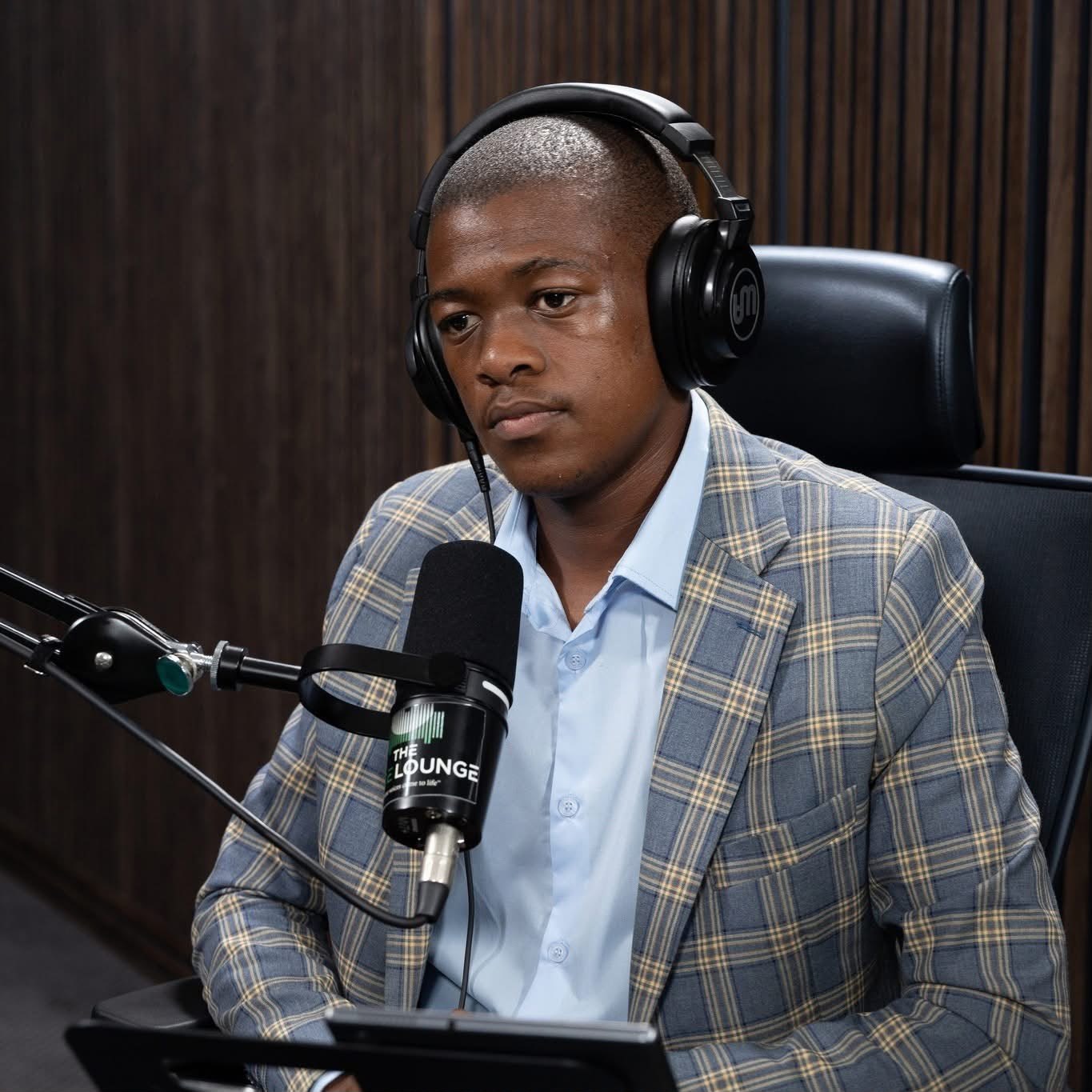 Cwenga Sihle Peter speaking into a studio microphone at The Voice Lounge