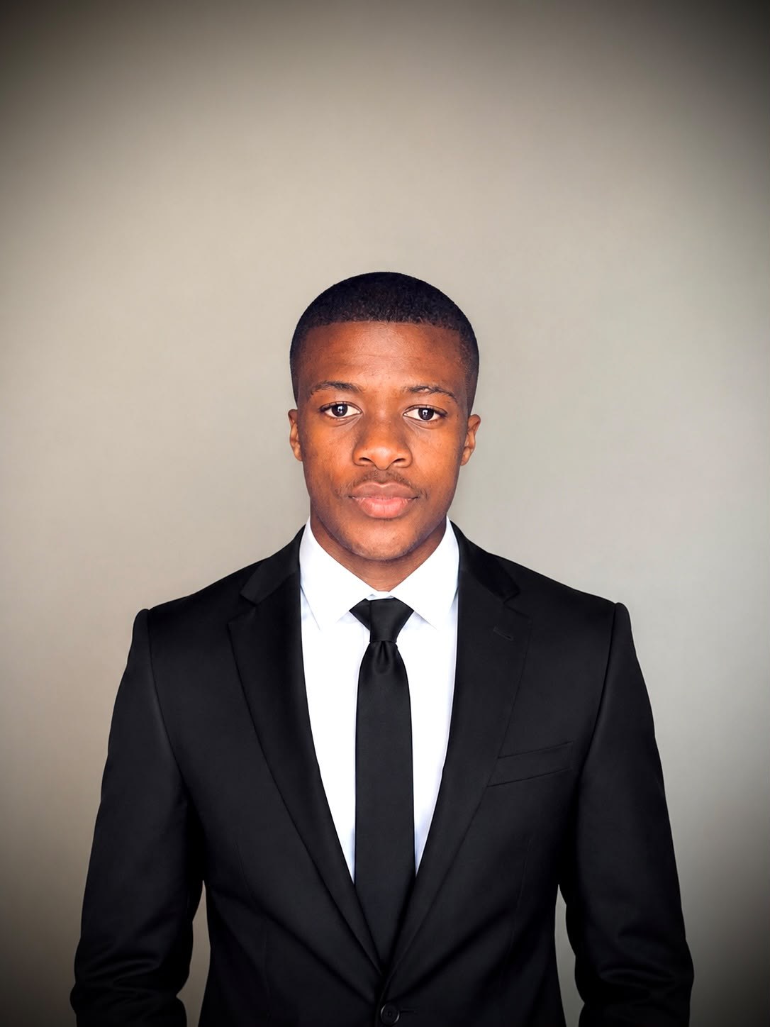Formal portrait of Cwenga Sihle Peter in a black suit
